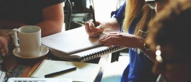 Tisch mit Studenten und Unterrichtsmaterial